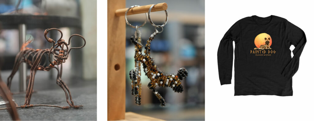 Left: a statue of a painted dog made from twisting the wires of repurposed snare traps.
Middle: A keychain of a painted dog made of wire from a snare trap and beads. 
Right: A black long sleeve shirt with an illustration of a painted dog lying down in front of an orange and yellow circle. The text "Painted Dog" is printed below it. 